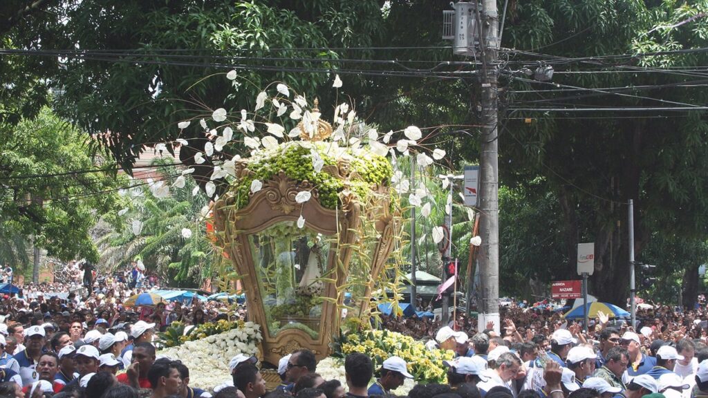 A berlinda florida com a imagem de Nossa Senhora de Nazaré avança entre a multidão do Círio em Belém