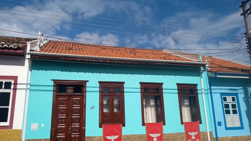 Casa colonial de São Luiz do Paraitinga enfeitada com bandeiras vermelhas e a pomba do Divino
