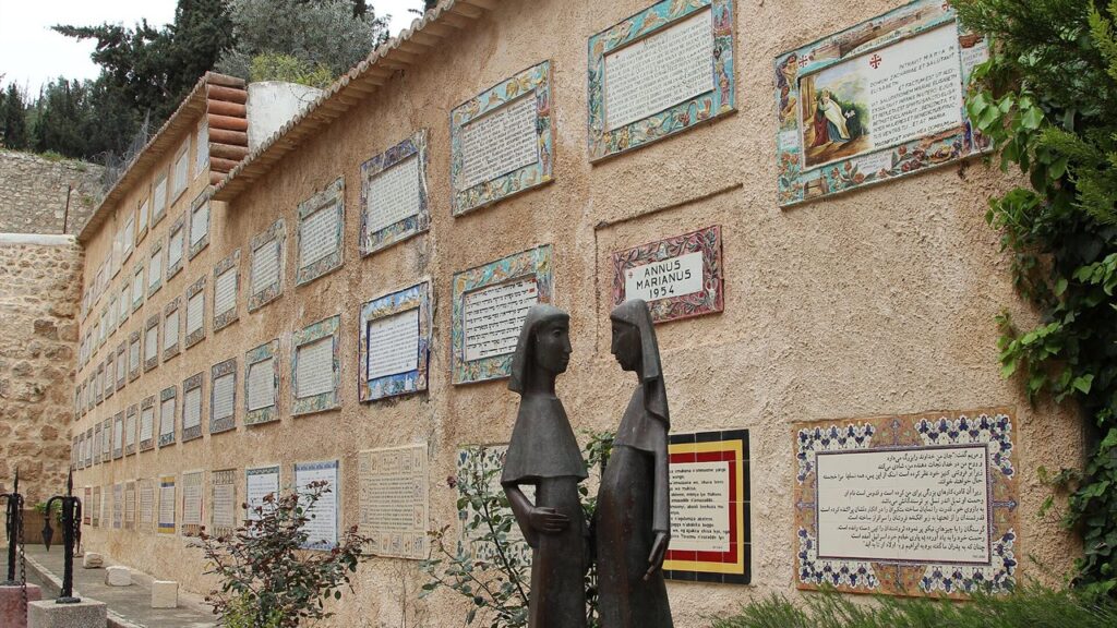 Escultura de Maria e Isabel diante dos painéis com o Magnificat em várias línguas, em Ain Karem