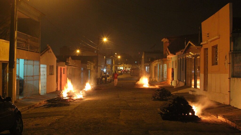 Fogueiras acesas diante das casas numa rua de Campina Grande na noite de São João