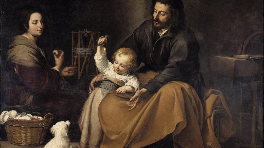 Jesus menino no colo de José mostra um passarinho, enquanto Maria fia ao lado: a vida simples da casa de Nazaré