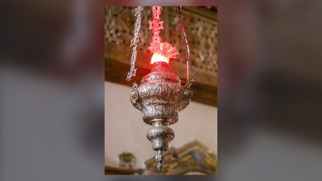 Lâmpada do Santíssimo de prata com luz vermelha, sinal da presença de Cristo no sacrário
