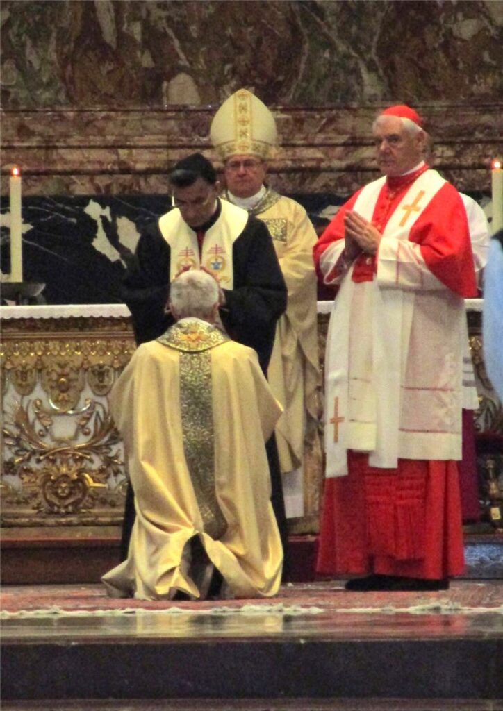 Bispo impõe as mãos sobre o eleito na ordenação episcopal, rito da sucessão apostólica