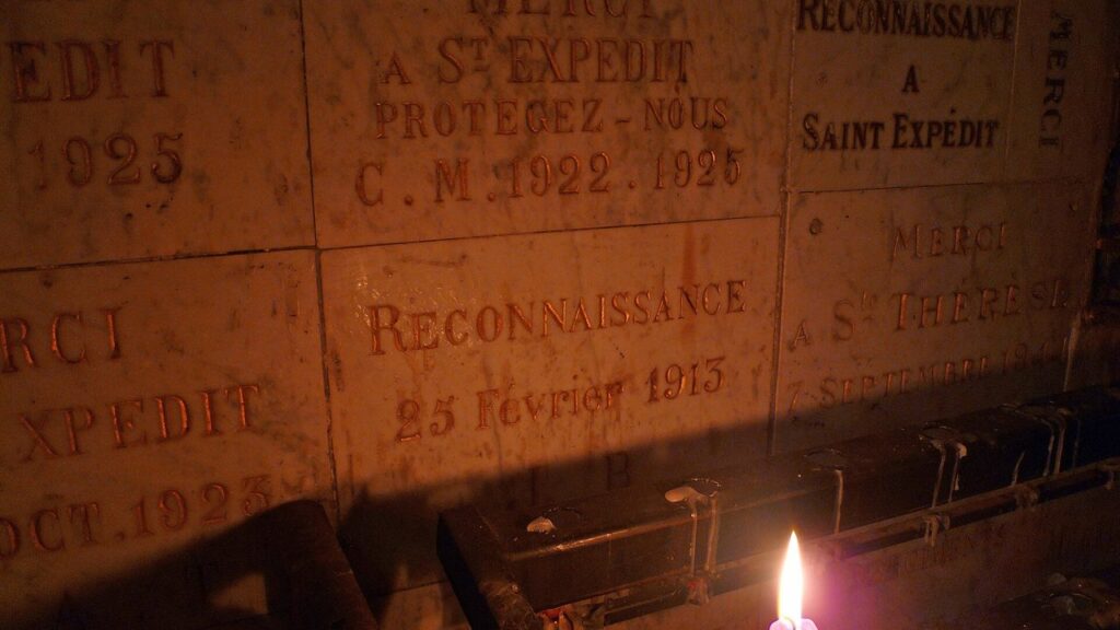 Placas de agradecimento a Santo Expedito e velas acesas na basílica da Daurade, em Toulouse