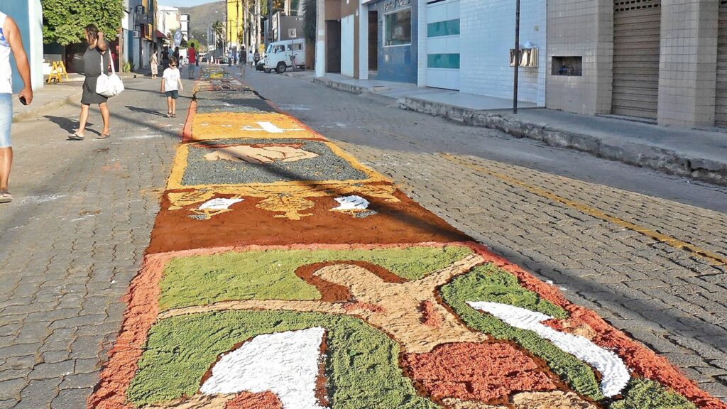 Tapete de Corpus Christi feito de serragem colorida numa rua de Minas Gerais, pronto para a procissão