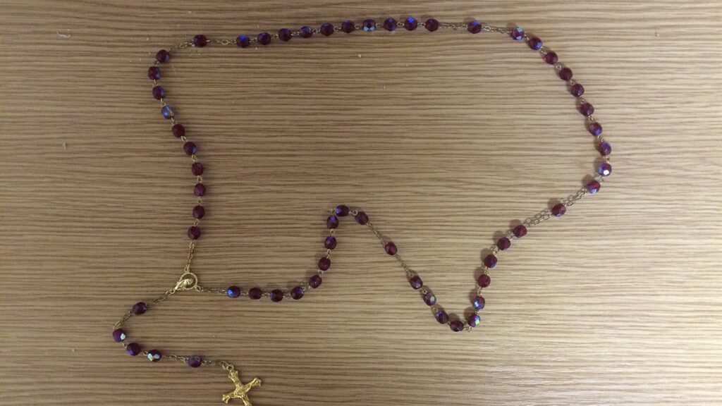 Terço de cinco dezenas com crucifixo e medalha, o objeto mais usado para rezar o rosário