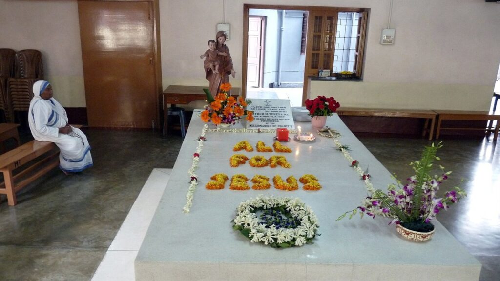 Túmulo de Santa Teresa de Calcutá na Casa Mãe, coberto de flores e visitado por peregrinos