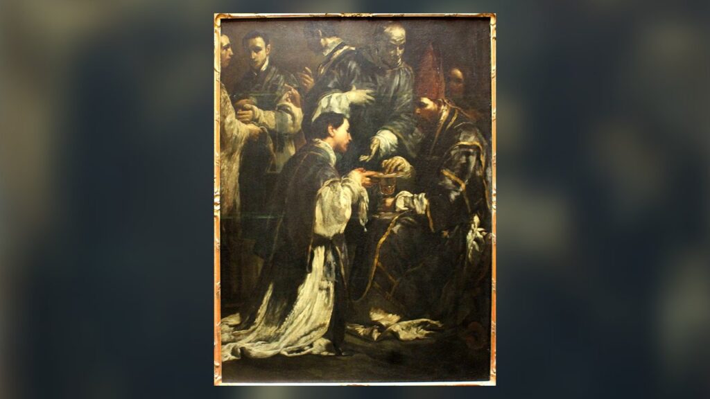 Um bispo entrega o cálice e a patena ao jovem que está sendo ordenado padre