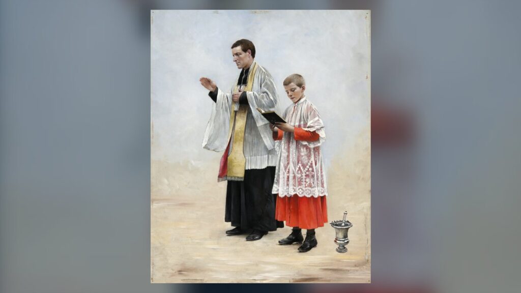 Um coroinha de batina vermelha e sobrepeliz segura o livro ao lado do sacerdote que abençoa